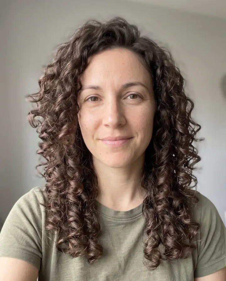 The same woman with long layered curls past her shoulders