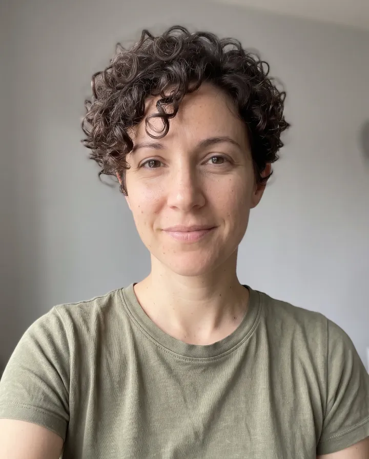 The same woman with a curly pixie cut