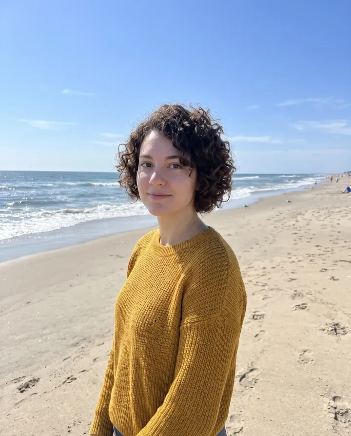 The woman on a sunny beach with the ocean behind her