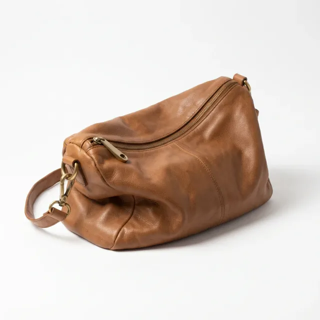 A brown leather handbag on a clean white background with a soft shadow