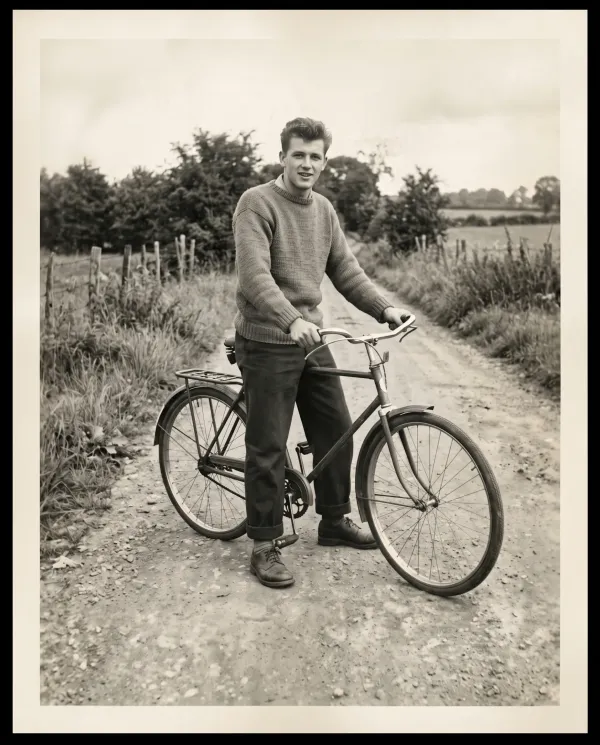 The same photo of the young man with his bicycle, the torn corner rebuilt